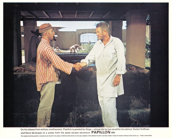 On his release from solitary confinement, Papillon is greeted by Dega