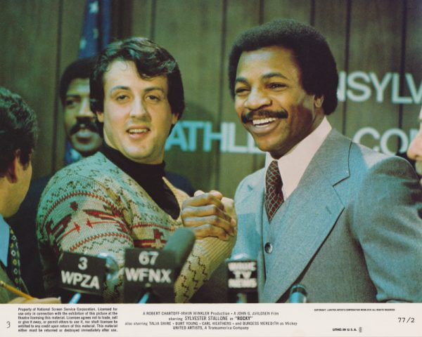 Card #03: All smiles as unknown Rocky Balboa attends a pre-fight media event with champion Apollo Creed