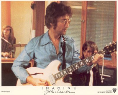 John Lennon playing guitar in a recording studio