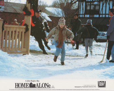 Kevin runs away from a local policeman in Home Alone (1990)