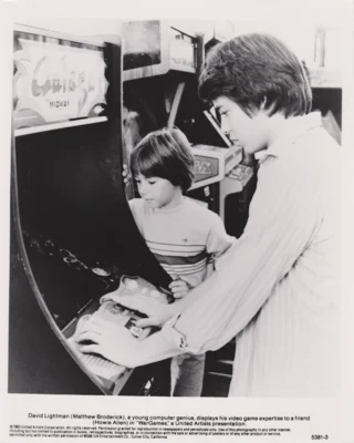 Matthew Broderick playing on a Galaga arcade videogame cabinet in a scene from WarGames (1983) [press photo]